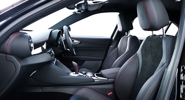 Front leather and alcantara seats in a Giulia QV from the passenger side door