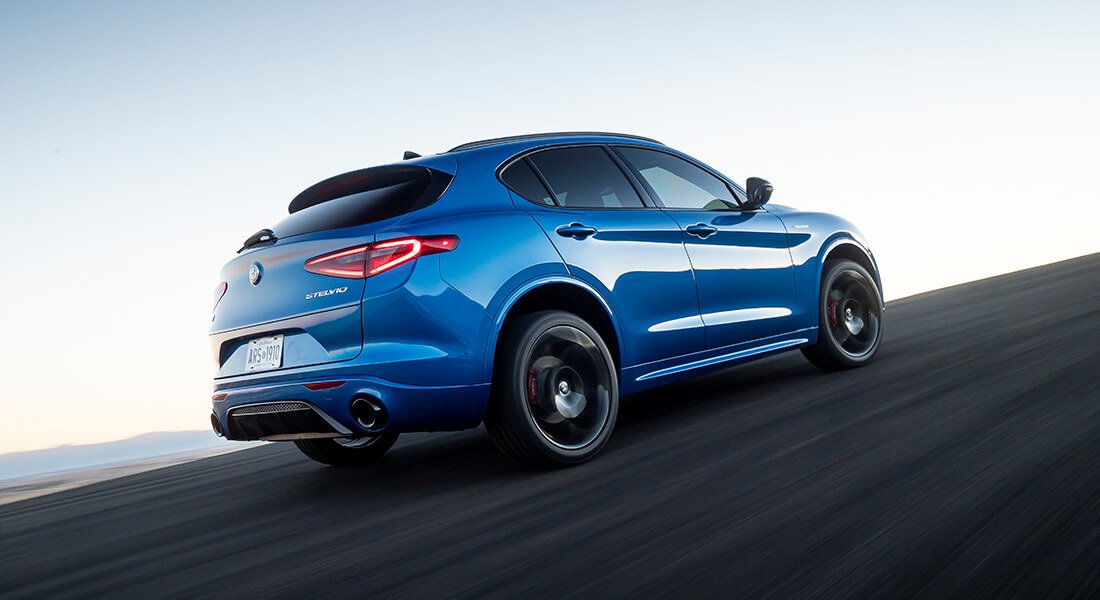 Rear 3/4 shot of a blue stelvio driving on a track
